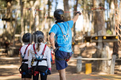 Instructor showing zip line to kids in park