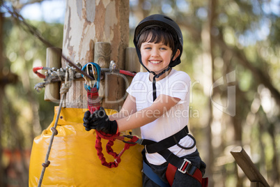 Cute boy enjoying zip line adventure on sunny day