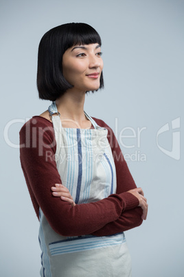 Waitress standing with arms crossed against white background