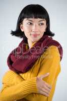 Woman in winter clothing posing against white background