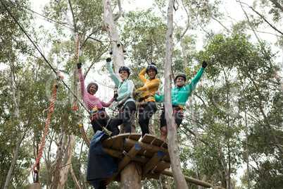 Friends enjoying zip line adventure in park