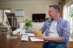 Man looking at computer while having coffee