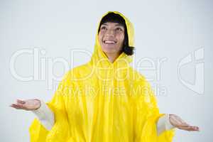 Woman in yellow raincoat gesturing to feel the rain