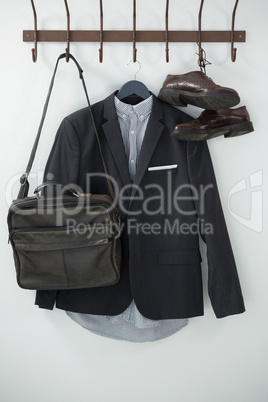 Close-up of blazer, shoes, and bag hanging on hook