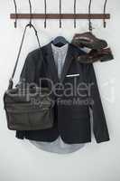Close-up of blazer, shoes, and bag hanging on hook
