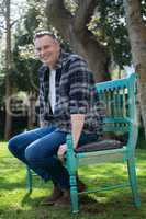 Smiling man sitting on bench in garden