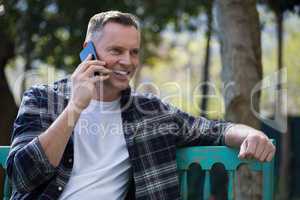 Man talking on mobile phone in garden