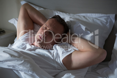 Man sleeping on bed in bedroom