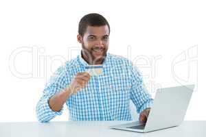 Male executive doing online shopping on laptop