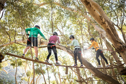 Friends enjoying zip line adventure in park