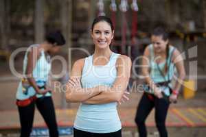 Beautiful woman standing with arms crossed in park