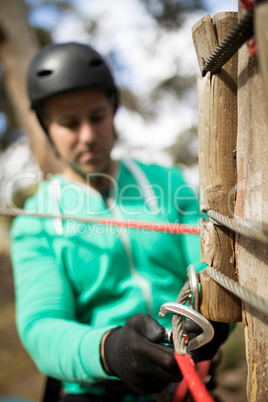 Man attaching carabiner to rope