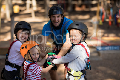 Instructor and kids forming hand stack in park