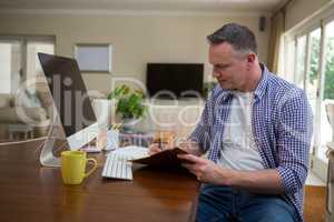 Man writing on diary in living room