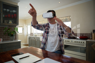 Man using virtual reality headset in kitchen