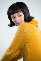 Woman in winter clothing posing against white background