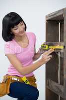Woman measuring furniture with tape measure
