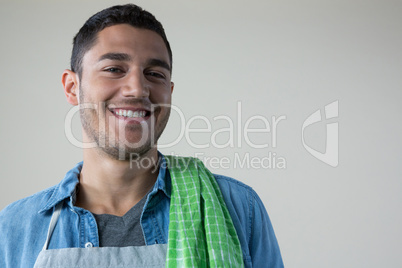 Smiling waiter with a green napkin on his shoulder
