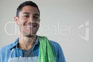 Smiling waiter with a green napkin on his shoulder