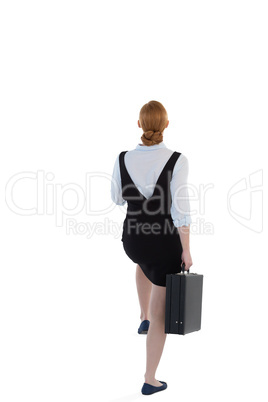 Female executive pretending to climb the steps against white background