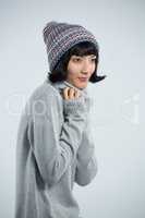 Woman in winter clothing posing against white background