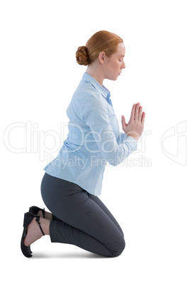 Businesswoman kneeling in prayer position