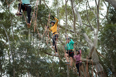 Friends enjoying zip line adventure in park