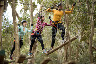 Friends enjoying zip line adventure in park