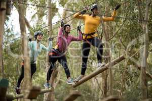 Friends enjoying zip line adventure in park