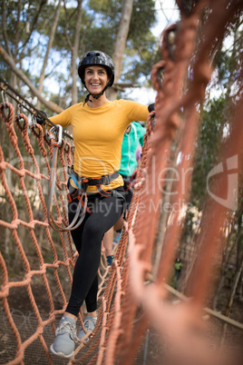 Woman walking on rope bridge