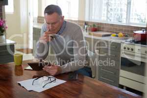 Man using digital tablet in kitchen