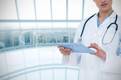 Composite image of focused doctor using her tablet pc