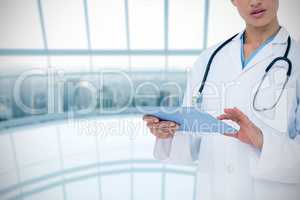 Composite image of focused doctor using her tablet pc