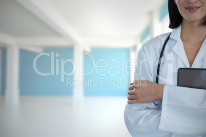 Composite image of portrait of happy female doctor standing with arms crossed