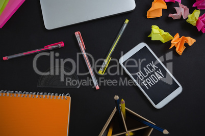 Composite image of laptop, mobile phone and stationery on black background