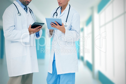 Composite image of doctors discussing something on clipboard