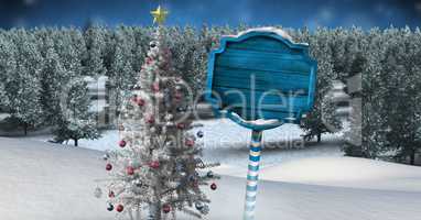 Wooden signpost in Christmas Winter landscape with Christmas tree