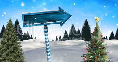 Wooden signpost in Christmas Winter landscape with Christmas tree