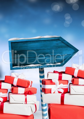 Gifts and Wooden signpost in Christmas Winter landscape