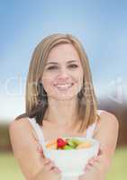 Fit healthy woman holding fruit in bowl