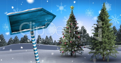 Wooden signpost in Christmas Winter landscape with Christmas tree