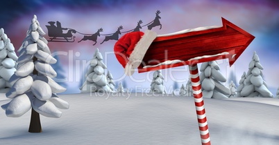 Wooden signpost in Christmas Winter landscape and Santa's sleigh and reindeer's