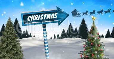 Christmas text on Wooden signpost in Christmas Winter landscape with Christmas tree and Santa's slei