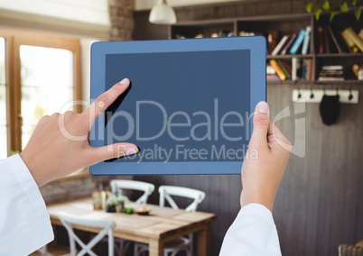 Hand holding tablet with cafe background