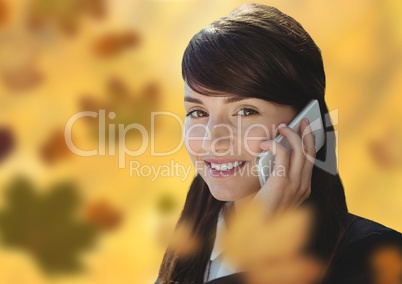 Woman on phone in forest with leaves