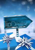 Gifts and Wooden signpost in Christmas Winter landscape