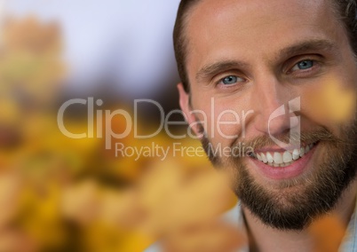 Man's face in landscape with leaves