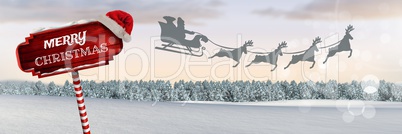 Merry Christmas text on Wooden signpost in Christmas Winter landscape and Santa's sleigh and reindee