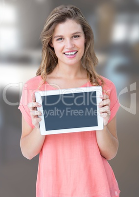 Woman holding tablet with office background