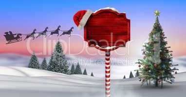 Wooden signpost in Christmas Winter landscape with Christmas tree and Santa's sleigh and reindeer's